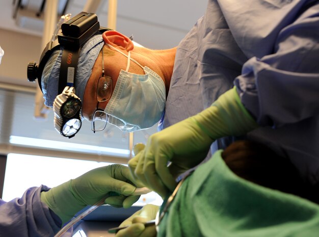 Capt. Aaron Cohenour, with help from dental assistant Tanya Maisonet, performs a wisdom tooth extraction on Senior Airman Chaley Dyer at Joint Base Charleston - Air Base April 11. Cohenour and Maisonet are from the 628th Medical Group and Dyer is from the 628th Security Forces Squadron. (U.S. Air Force photo / Airman 1st Class Ashlee Galloway)