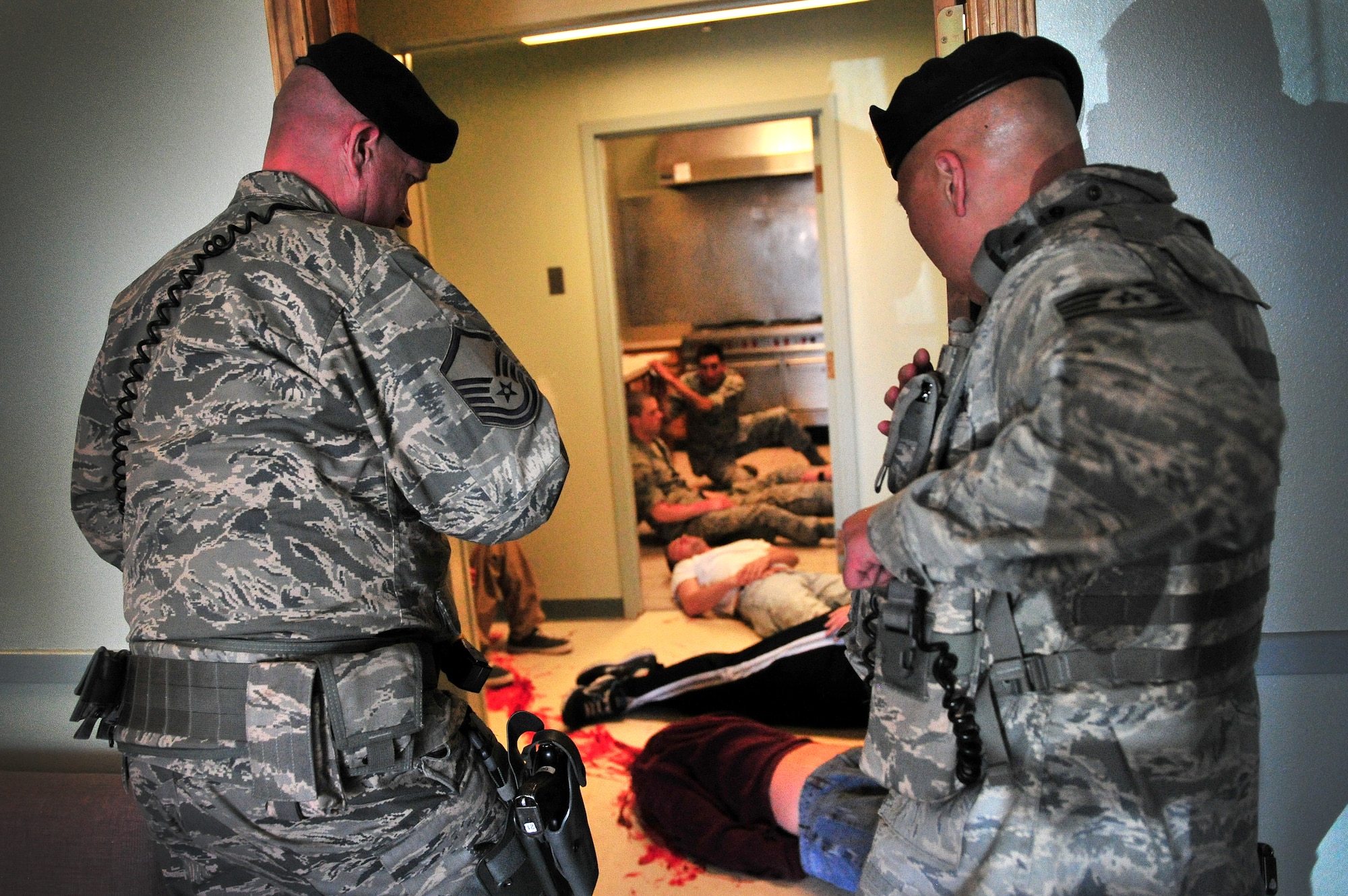 U.S. Air Force Master Sgt. Eric Griffith and Staff Sgt. Joseph Soriano, 27th Special Operations Security Forces Squadron, survey the scene of a simulated tornado during a natural disaster exercise at Cannon Air Force Base, N.M., April 5, 2012. Training exercises provide a safe and controlled environment to practice tactics, techniques and procedures. (U.S. Air Force photo by Tech. Sgt. Josef Cole)