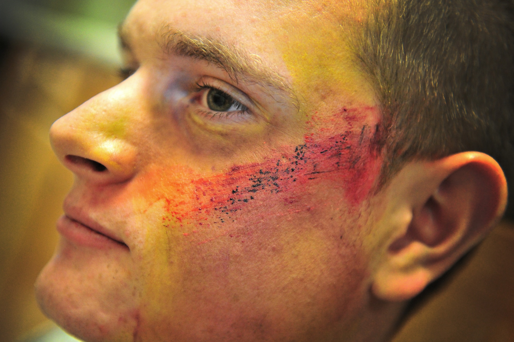 U.S. Air Force Airman 1st Class Anthony Hammock, acts as a silmulated tornado victim by displaying a burn wound made with makeup, while waiting for help to arrive during a natural disaster exercise at Cannon Air Force Base, N.M., April 5, 2012. Training exercises provide a safe and controlled environment to practice tactics, techniques and procedures. (U.S. Air Force photo by Tech. Sgt. Josef Cole)
