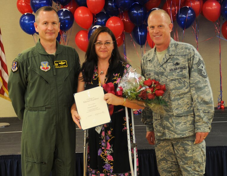 U.S. Air Force Col. Billy Thompson, 23d Wing commander, and Chief Master Sgt. Frank Batten, 23d WG command chief, present the Volunteer Excellence award to Victoria Wood during the 2012 Annual Volunteer Recognition Ceremony at Moody Air Force Base, Ga., April 17, 2012. Wood served as the 820th Base Defense Group lead for organizing volunteer efforts at the Hopes and Dreams Riding Facility. (U.S. Air Force photo by Airman 1st Class Douglas Ellis/Released)
