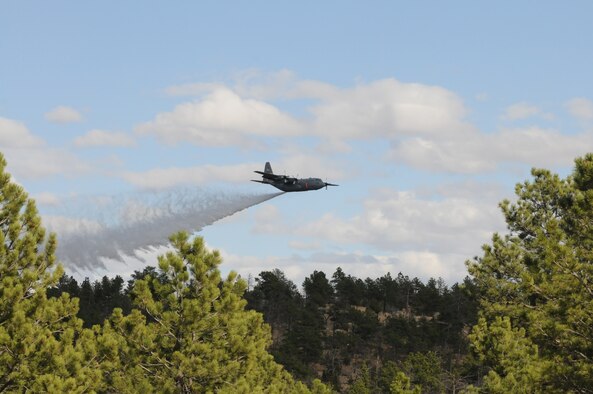 A C-130 assigned to the 153rd Airlift Wing, Wyoming Air National Guard, drops water during Modular Airborne Firefighting System (MAFFS) training April 16, 2012, over Camp Guernsey Joint Training Center, Wyo. Annual training is conducted to maintain currency and upgrade qualifications for pilots, aircrew and ground crews in preparation for the fire season. (Photo by Mr. Dewey Baars)