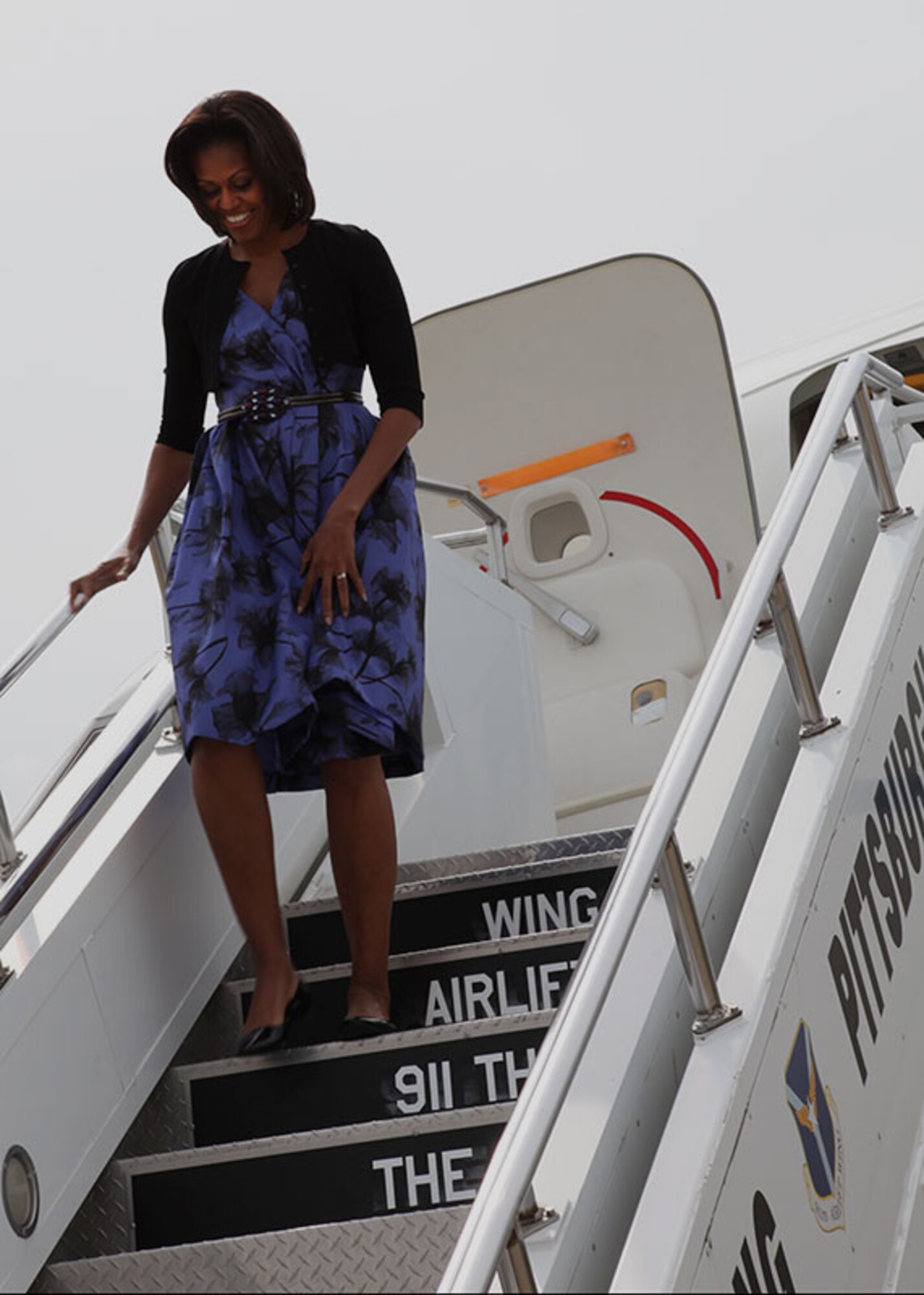 First Lady Michelle Obama smiles while walking down the stair truck before she meets the 911th welcoming party, April 17, 2012. Mrs. Obama personally greeted more than 20 military and family members from the 911th Airlift Wing and the neighboring 171st Air Refueling Wing, Pennsylvania Air National Guard.  (U.S. Air Force photo by Tech. Sgt. Ralph Van Houtem/Released)