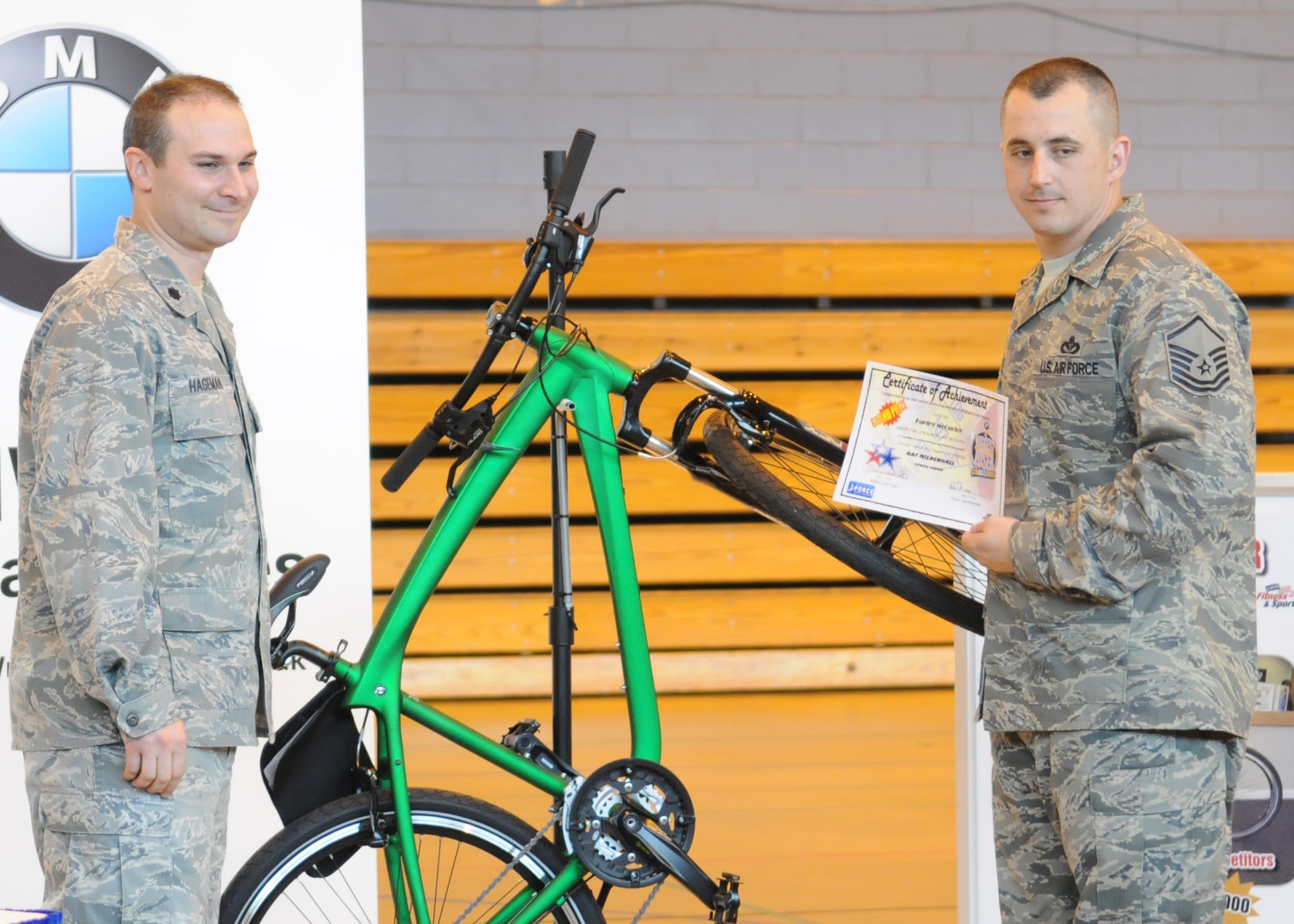 RAF MILDENHALL, England – Lt. Col. Adrian Hageman, 100th Force Support Squadron commander, presents Master Sgt. Harley McCurder, 100th Civil Engineer Squadron, the grand prize – a BMW bike – for winning the RAF Mildenhall Biggest Loser Competition April 17, 2012, at the North Side Fitness Center.  In three months, McCurder lost 50 pounds, 10.5 inches from his waist and 10 percent body fat.  (U.S. Air Force photo/Staff Sgt. Tabitha M. Lee)