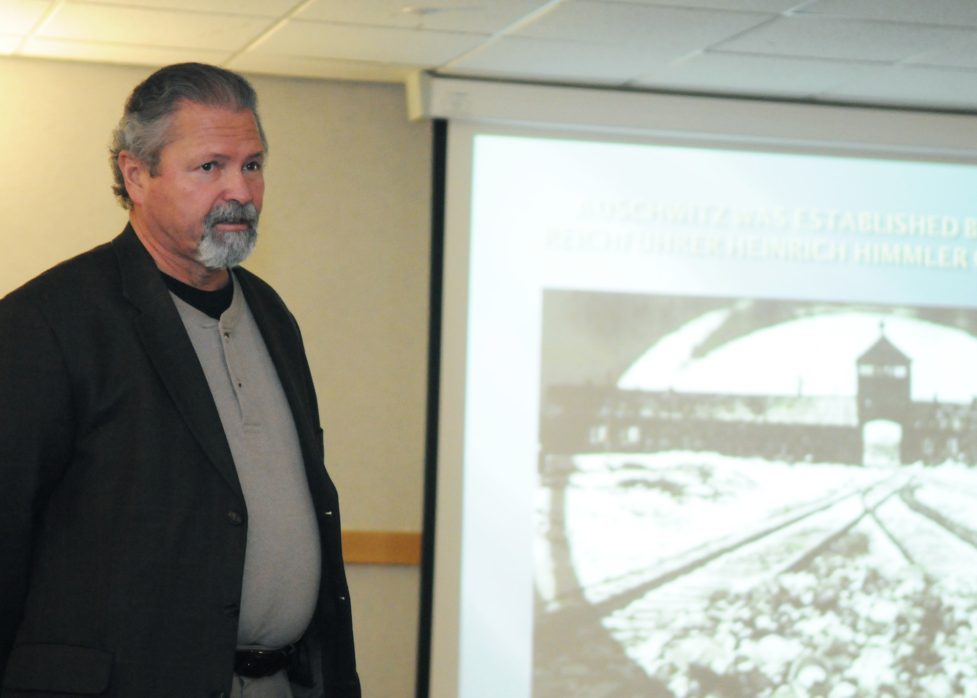 RAF MILDENHALL, England – Mark Howell, 100th Air Refueling Wing base historian, speaks during a Holocaust Remembrance Lecture April 17, 2012, at the 100th Operations Group auditorium.  Throughout Holocaust Remembrance Week, April 16 to 20, there are historical displays at the Gateway Dining Facility to educate base members on the Holocaust.  (U.S. Air Force photo/Staff Sgt. Tabitha M. Lee)