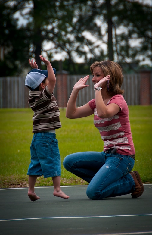 Three-year-old Hunter, and his mother Tricia, wife of Staff Sgt. Justin Hoffman, 15th Airlift Squadron loadmaster, 437th Airlift Wing, give each other a high-five after playing basketball at a Joint Base Charleston – Air Base park April 14. Hunter was recently diagnosed with moderate to severe classical autism. Hunter struggles with speaking, making eye contact and basic social skills. Even though Hunter struggles with simple things such as speaking or social interactions, he is very coordinated and can retain large amounts of information. (U.S. Air Force photo by Airman 1st Class Dennis Sloan)