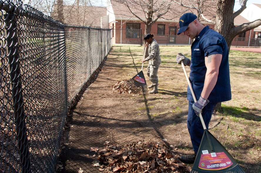 HANSCOM AIR FORCE BASE, Mass -- U.S. Coast Guard Petty Officer 3rd Class Christopher Hannon and Senior Airman Eboni Briscoe-Jenkins, both Airman Leadership School students, rake leaves at the Child Development Center March 30. Each class performs a community service project as part of their curriculum. (U.S. Air Force photo by Mark Wyatt)