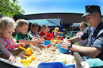 Petty Officer 3rd Class Steven Swan helps build sand castles a group of toddlers at the Child Development Center at Joint Base Charleston – Weapons Station April, 11. Swan, a Machinist’s Mate from Rockmart, Ga., works at the CDC while he waits on his next set of orders. (U.S. Navy photo/Petty Officer 1st Class Jennifer Hudson)
