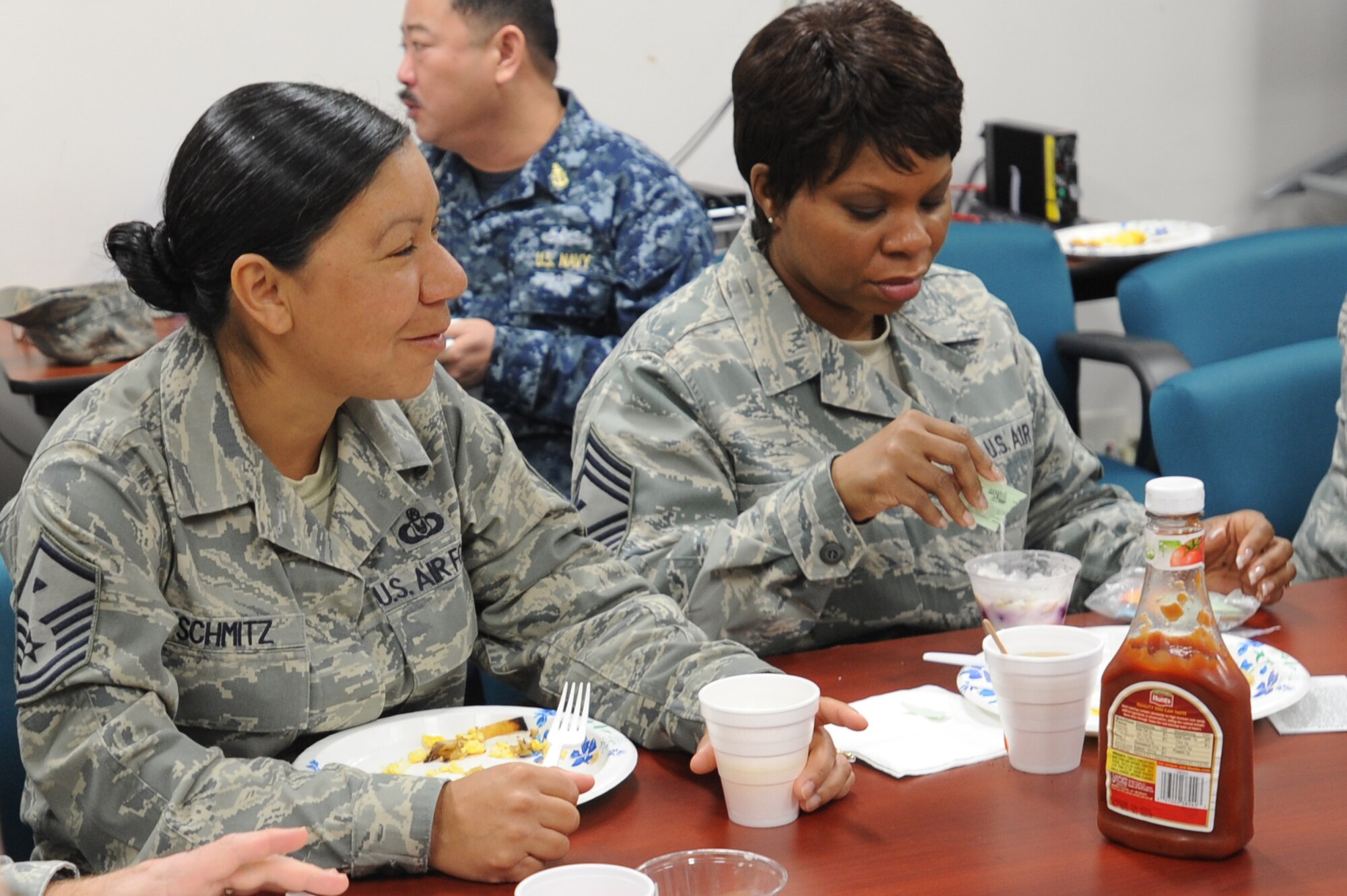 U.S. Air Force Master Sgt. Cynthia Schmitz, left, 35th Force Support Squadron first sergeant, and Chief Master Sgt. Felicia Noil, 35th Maintenance Squadron first sergeant, converse with other first sergeants while eating breakfast in the 35th Medical Group Mental Health Flight conference room during the quarterly first sergeants' appreciation breakfast at Misawa Air Base, Japan, April 18, 2012. Schmitz and Noil were two of approximately 10 first sergeants who participated in the breakfast, the Month of the Military Child and Child Abuse Awareness. (U.S. Air Force photo by Airman Kenna Jackson/Released)
