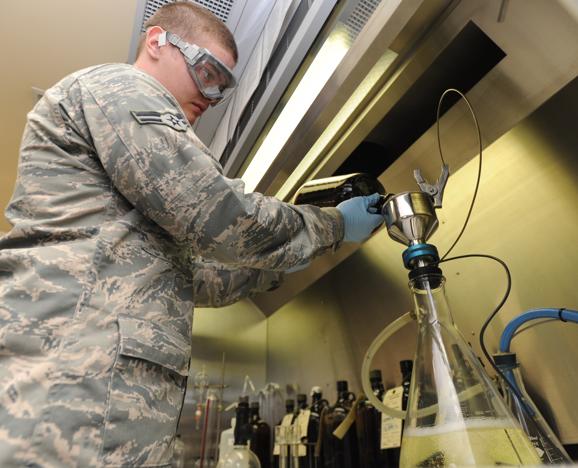 U.S. Air Force Airman 1st Class Jesse King, 35th Fuels Management fuels laboratory technician, uses the bottle apparatus method to perform a particulate matter test of jet fuel at Misawa Air Base, Japan, April 17, 2012. This test is performed to determine the amount of particulate matter in jet fuel. (U.S. Air Force photo by Airman Kenna Jackson/Released)