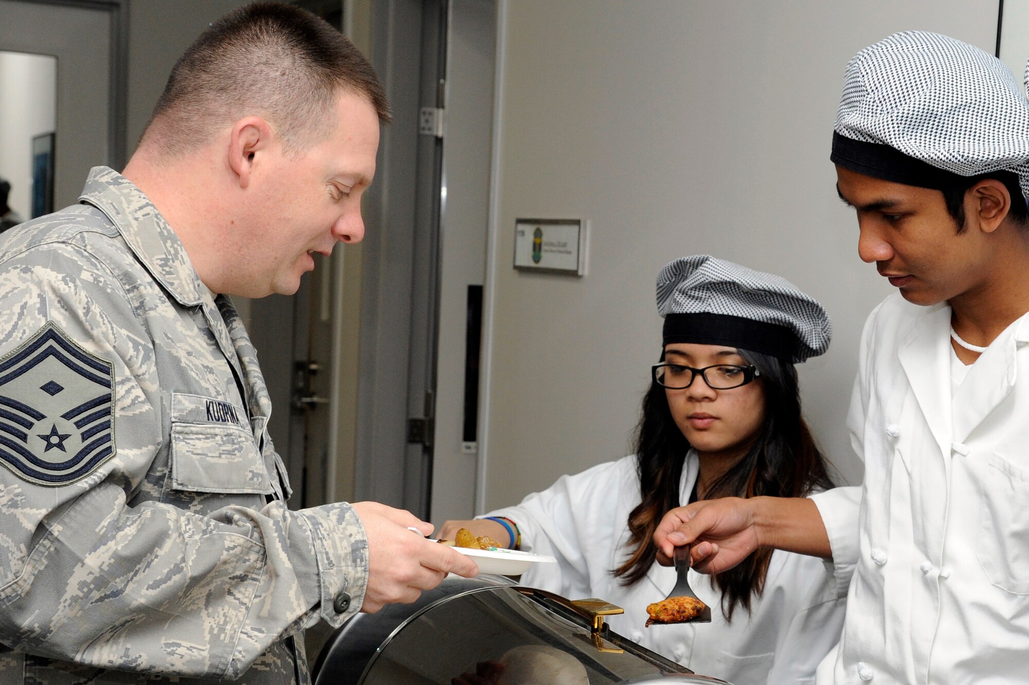 The son of Nathan Thiesse, right, Misawa Security Operations Center contractor, serves a crab cake to U.S. Air Force Senior Master Sgt. William Kudrna, 35th Aircraft Maintenance Squadron first sergeant, during the quarterly first sergeants' appreciation breakfast at Misawa Air Base, Japan, April 18, 2012. In recognition of The Month of the Military Child and Child Abuse Awareness, the 35th Medical Group Mental Health Flight coordinated this breakfast to celebrate the sacrifices that children make to the mission. (U.S. Air Force photo by Tech. Sgt. Marie Brown/Released)
