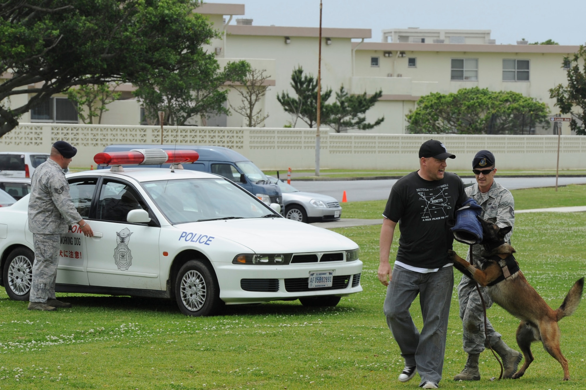 Members of the 18th Security Forces Squadron catch a "criminal" during the K-9 demonstration on Kadena Air Base, Japan, April 14, 2012. The 18th SFS uses K-9s for contraband searches as well as escorting and capturing criminals. (U.S. Air Force photo by Airman 1st Class Justin Veazie/released)