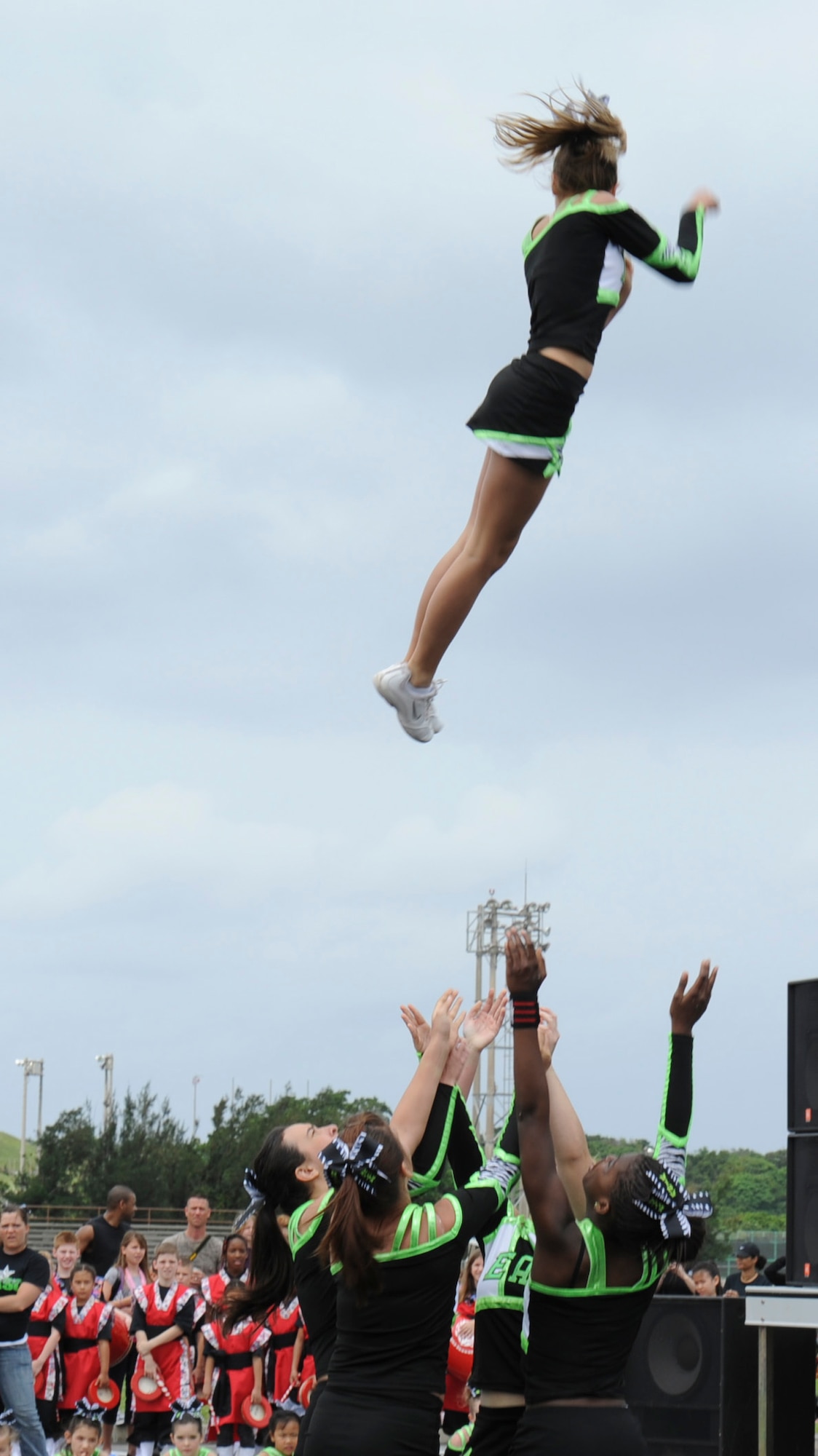 Eagles All-Star cheerleaders toss one of their team members into the sky to complete a basket toss during the second annual EarthFest on Kadena Air Base, Japan, April 14, 2012. A basket toss is a stunt performed in cheerleading using three or more bases to toss a flyer into the air. While in the air, the flyer does some type of jump, ranging from toe-touches to herkies before returning to the cradle. (U.S. Air Force photo by Airman 1st Class Justin Veazie/released)