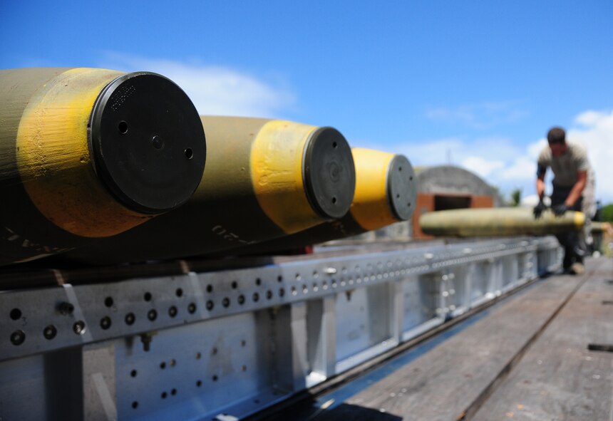 Andersen Air Force Base, Guam- An AMMO troop from the 36th Munitions Squadron rolls a bomb onto a trailer for transport during the Pre Combat Ammunition Production Exercise April 9. During the CAPEX approximately 100 inspectors will evaluate the processes and procedures for building munitions to support the wing’s operational plan.  (U.S. Air Force photo by Senior Airman Jeffrey Schultze)