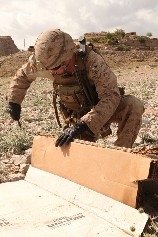 A Marine serving with 1st Battalion, 8th Marine Regiment, Police Advisory Team 1, prepares cardboard targets for a rifle marksmanship range here, April 19, 2012. Officers of the Afghan Uniformed Police practiced their leadership and marksmanship skills. (U.S. Marine Corps photo by Lance Cpl. Tyler Reiriz)