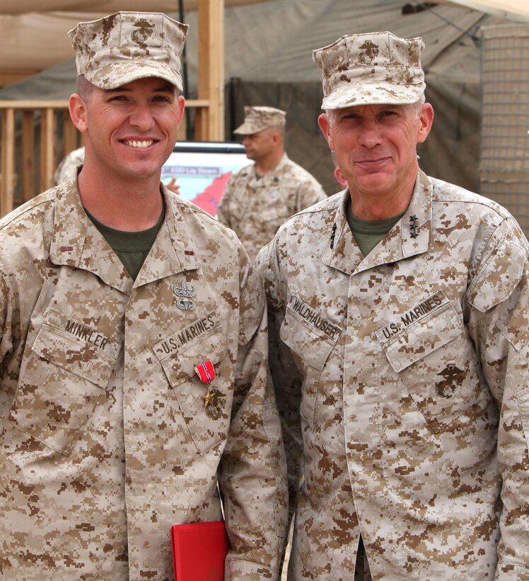 Warrant Officer Kelly Minkler, (left), operations officers, 1st Explosive Ordnance Disposal Company, 1st Marine Logistics Group (Forward), stands with Lt. Gen. Thomas Waldhauser, the commanding general of Marine Corps Forces Central Command, after being awarded the a Bronze Star with a Combat Distinguishing Device, April 18. After rendering safe a never before seen improvised explosive device, Minkler was able to train EOD technicians and infantrymen throughout the battle space on new enemy tactics, techniques and procedures.