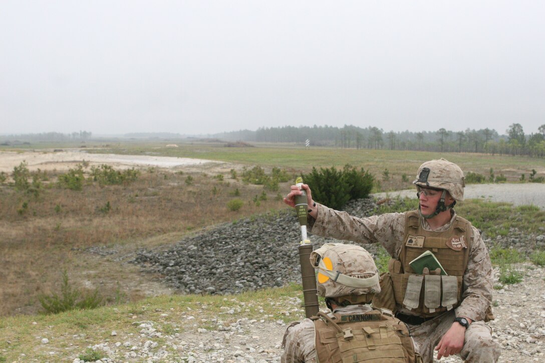 – Sergeant Justin Vandertang (right), mortarman, Company G, 2nd Battalion, 2nd Marine Regiment, loads a 60 millimeter, high-explosive round into the M224A1 mortar system his unit trained with during a range exercise.  The Black River, N.Y., native with 2nd Marine Division said he loves the changes that have been made to the M224A1 over its predecessor, the M224 Legacy.  He said his favorite change is the new weight of the system which, at 35 pounds, if a full nine pounds lighter than the M224 Legacy, an important feature considering Marines carry them on their backs during patrols lasting several hours.