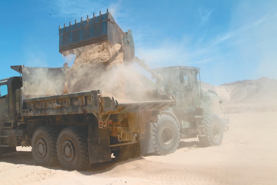 A bulldozer dumps sand into the back of a 7-ton truck during Company A, 7th Engineer Support Battalion’s visit to the Combat Center to construct a parking lot where deployed Marines can leave their personal vehicles April 19, 2012.