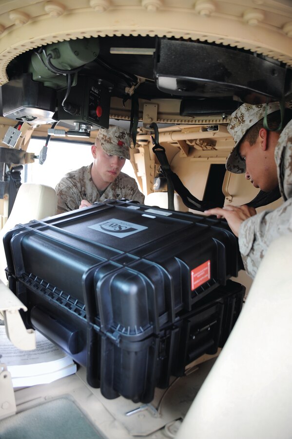 Lance Cpl. Edgar Galvan, right, heavy equipment operator, Combat Logistics Regiment 1, Camp Pendleton, Calif., and Lance Cpl. Nicholas Nation, landing support specialist, CLR 37, Okinawa, Japan, load a portable deployment kit inside a Humvee for training, April 5.::r::::n::::r::::n::