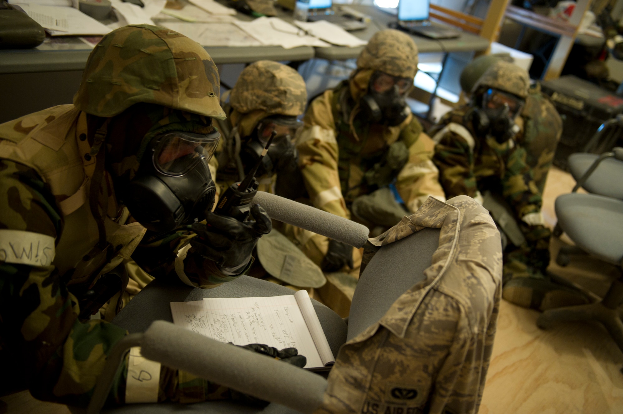 HOLLOMAN AIR FORCE BASE, N.M. – Airmen from the 49th Civil Engineer and Materiel Maintenance Squadrons take cover under a hardened shelter in level four mission-oriented protective postures during a Bivouac exercise April 11. During a simulated base attack, Airmen sought immediate shelter in a solid-structure as a preventative measure, as well as donned chemical protection gear to protect themselves from any possible form of bio-warfare used by hostile forces. (U.S. Photo by Airman 1st Class Michael Shoemaker/Released)