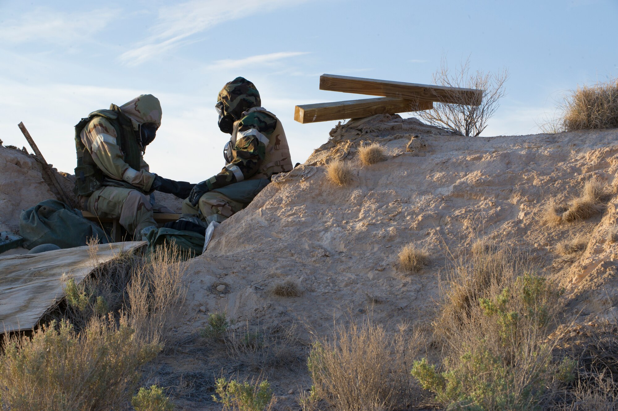 HOLLOMAN AIR FORCE BASE, N.M. – Airmen from the 49th Civil Engineer and Materiel Maintenance Squadrons assume level four mission-oriented protective postures, including rubber gloves, boots, gas masks, and a chemical protection suit, during a Bivouac exercise April 11. Level four MOPP gear gives protection for chemical, biological, radiological, nuclear and explosive materials. (U.S. Photo by Airman 1st Class Michael Shoemaker/Released)