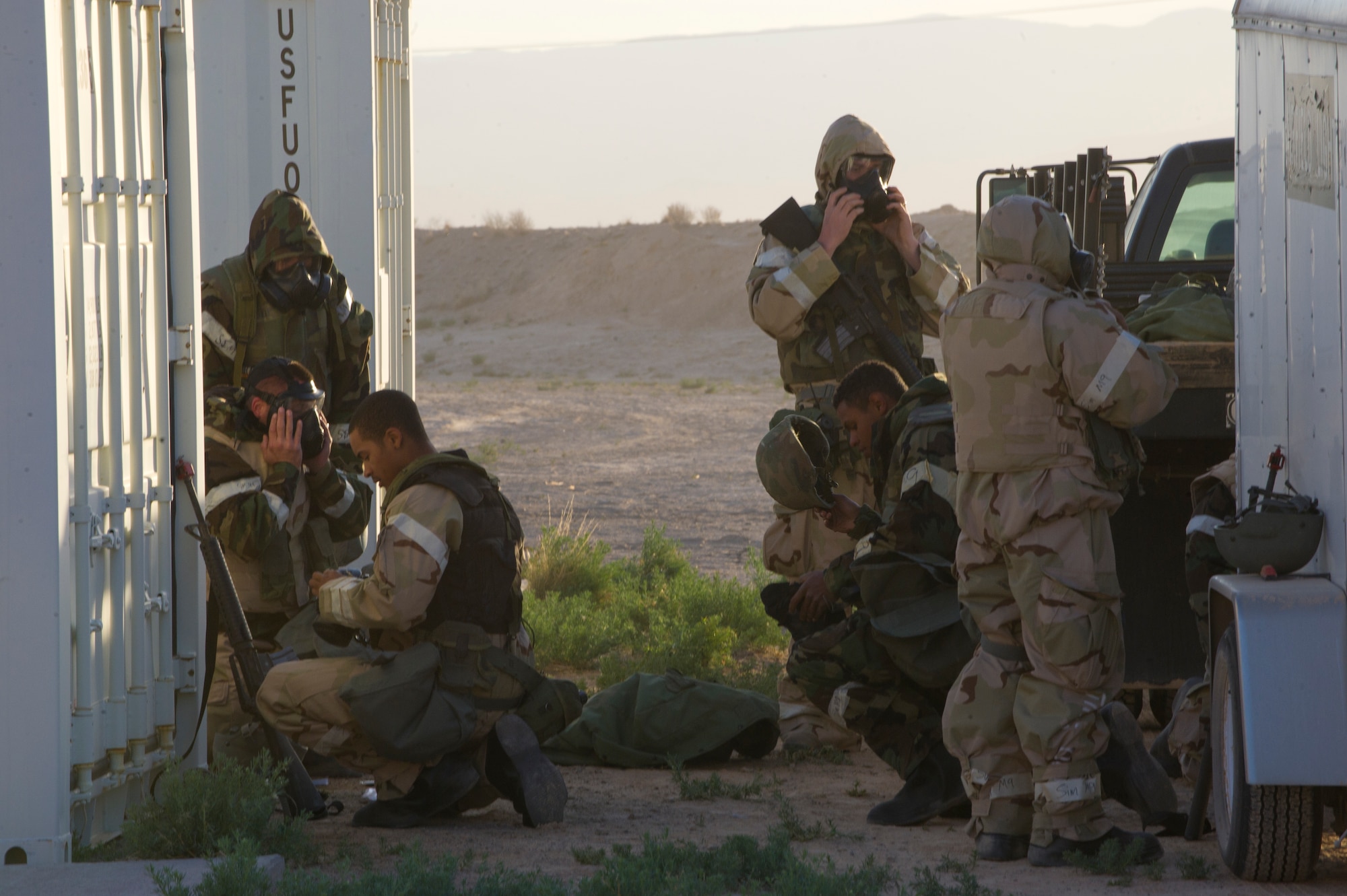 HOLLOMAN AIR FORCE BASE, N.M. – Airmen from the 49th Civil Engineer and Materiel Maintenance Squadrons assume level four mission-oriented protective postures, including rubber gloves, boots, gas masks, and a chemical protection suit, during a Bivouac exercise April 11. Level four MOPP gear gives protection for chemical, biological, radiological, nuclear and explosive materials. (U.S. Photo by Airman 1st Class Michael Shoemaker/Released)