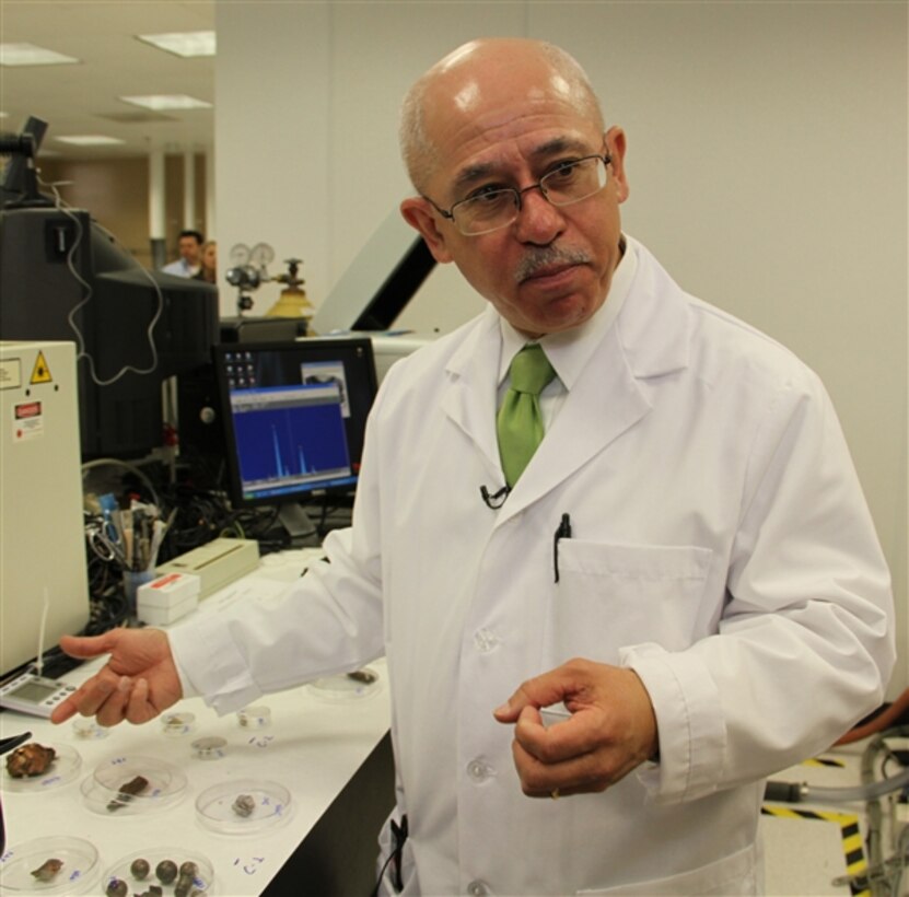 Dr. Jose Centeno, director of the Joint Pathology Center’s Biophysical Toxicology and Depleted Uranium/Embedded Metal Fragment Laboratories, demonstrates the variety of shrapnel pieces removed from service members and veterans. (DOD photo by Terri Moon Cronk)  
