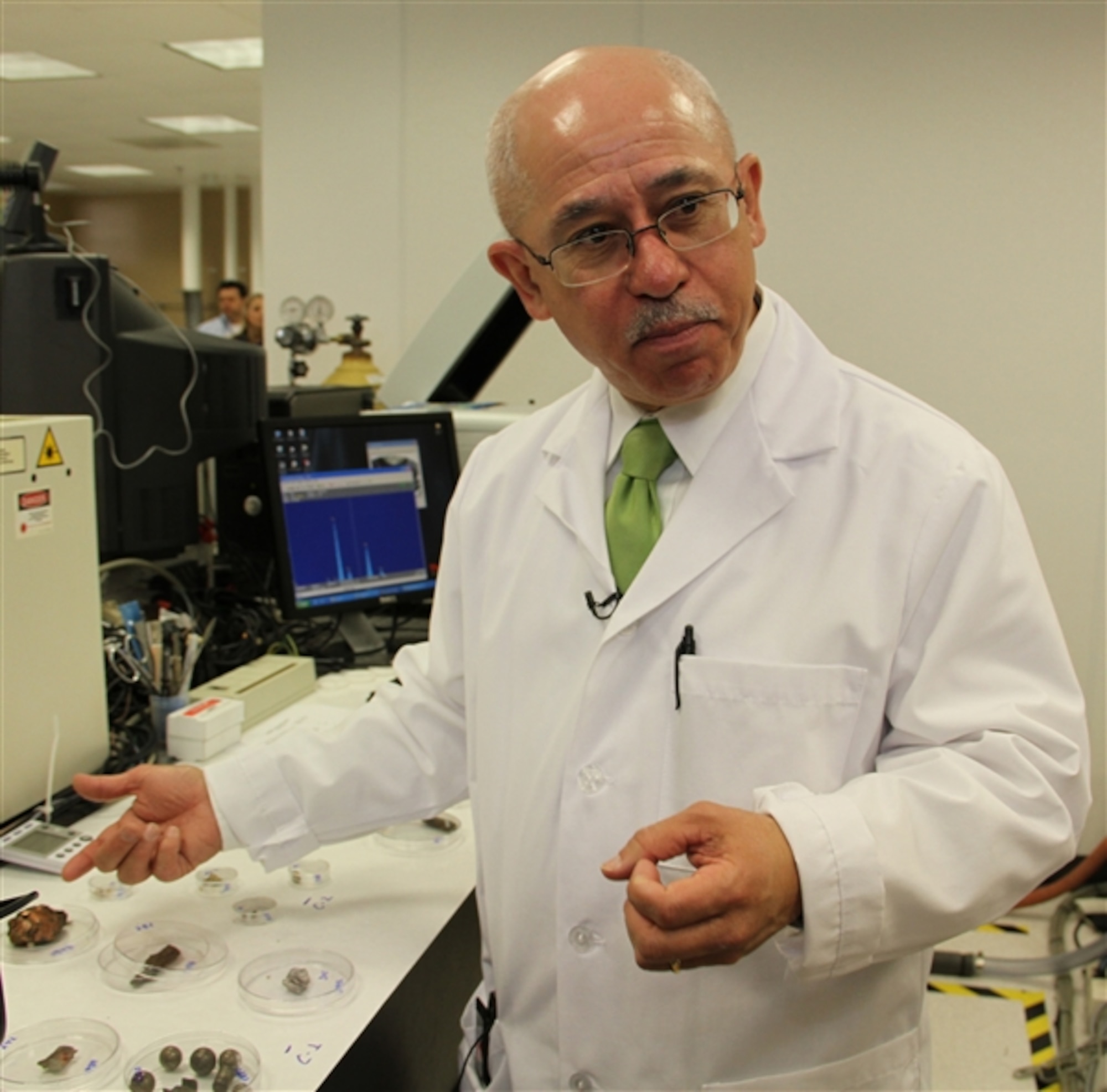 Dr. Jose Centeno, director of the Joint Pathology Center’s Biophysical Toxicology and Depleted Uranium/Embedded Metal Fragment Laboratories, demonstrates the variety of shrapnel pieces removed from service members and veterans. (DOD photo by Terri Moon Cronk)  

