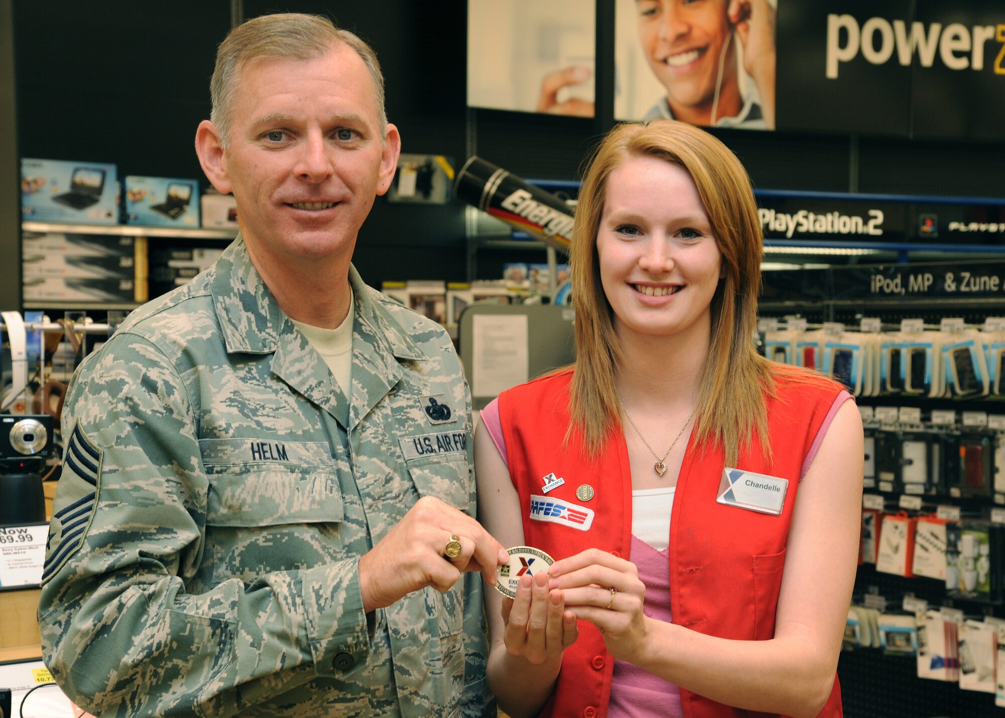 Chief Master Sgt. Jeffry Helm, senior enlisted advisor for the Army & Air Force Exchange Service, poses for a photo with AAFES employee Chandelle Myers on April 19, 2012, at the Base Exchange on Grand Forks Air Force Base, N.D. Helm toured Exchange facilities, plus met with employees and addressed Exchange-related issues. (U. S. Air Force photo/Senior Airman Amber Bennett)