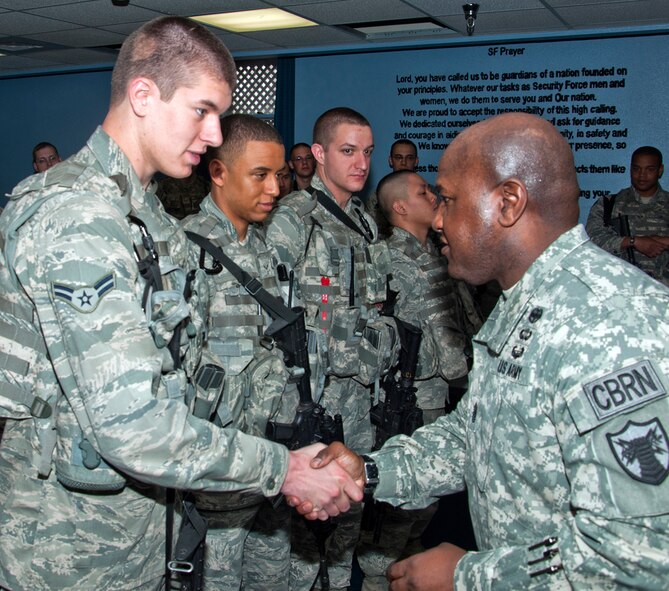 Army Command Sgt. Maj. Patrick Alston, United States Strategic Command senior enlisted leader, coins Airman 1st Class Ryan Landers, 90th Missile Security Forces Squadron, in the 90th Security Forces Group Headquarters during a visit to F. E. Warren Air Force Base, Wyo., April 10. Alston asked the NCOs in 90th MSFS, Flight 9, to select their most deserving Airmen, and they selected Landers, Airman 1st Class Edward Fortuna Clase, Airman 1st Class Steven Garwood and Airman Benjamin Le. Alston presented a challenge coin to each of them. (U.S. Air Force photo by Airman Jason Wiese)