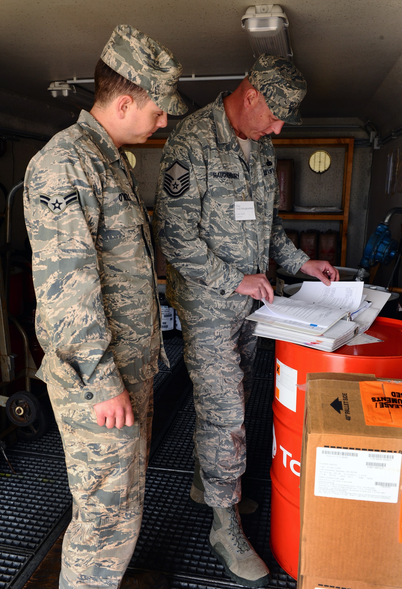 SPANGDAHLEM AIR BASE, Germany – Airman 1st Class Jared O’Neill, left, 52nd Civil Engineer Squadron electrical power production apprentice, and Master Sgt. Chad Haughenbury, U.S. Air Forces in Europe hazardous material manager, ensure the work center’s material safety data sheet binder is labeled and updated during an Environmental, Safety and Occupational Health Compliance Assessment Management Program evaluation outside the power production building here April 18. The week-long ESOHCAMP assessment gives the base an idea of how its compares to U. S. Air Force and host-nation regulations regarding environmental and occupational safety. This team is made up of 15 USAFE evaluators who assess Spangdahlem AB’s overall health. The base uses the results from the program to help become USAFE’s most environmentally friendly wing. (U.S. Air Force photo by Airman 1st Class Dillon Davis/Released)