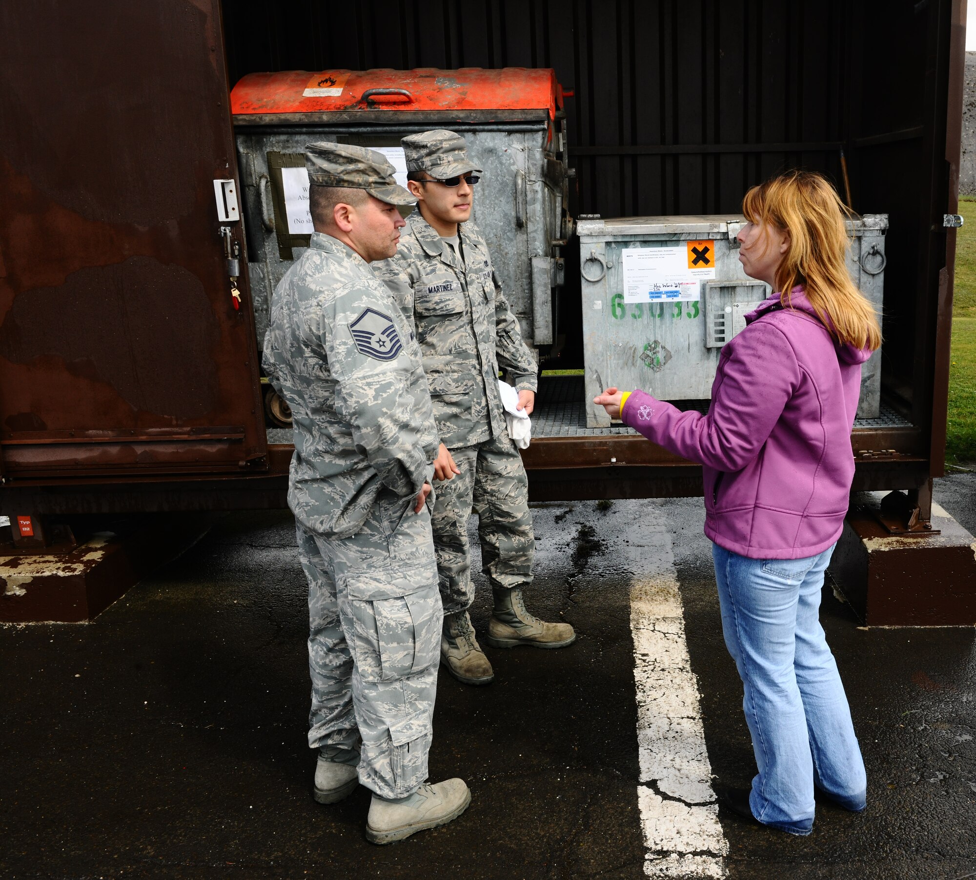 SPANGDAHLEM AIR BASE, Germany – Left to right, Master Sgt. Thomas McGrew and Staff Sgt. Jesus Martinez, 52nd Civil Engineer Squadron power production technicians, and Steffanie Metzger, U.S. Air Forces in Europe hazardous materials and waste manager, talk about proper labeling and upkeep of secondary storage containers during an Environmental, Safety and Occupational Health Compliance Assessment Management Program evaluation outside the power productions building here April 18. The week-long ESOHCAMP assessment gives the base an idea of how its compares to U. S. Air Force and host-nation regulations regarding environmental and occupational safety. This team is made up of 15 USAFE evaluators who assess Spangdahlem AB’s overall health. The base uses the results from the program to help become USAFE’s most environmentally friendly wing. (U.S. Air Force photo by Airman 1st Class Dillon Davis/Released)