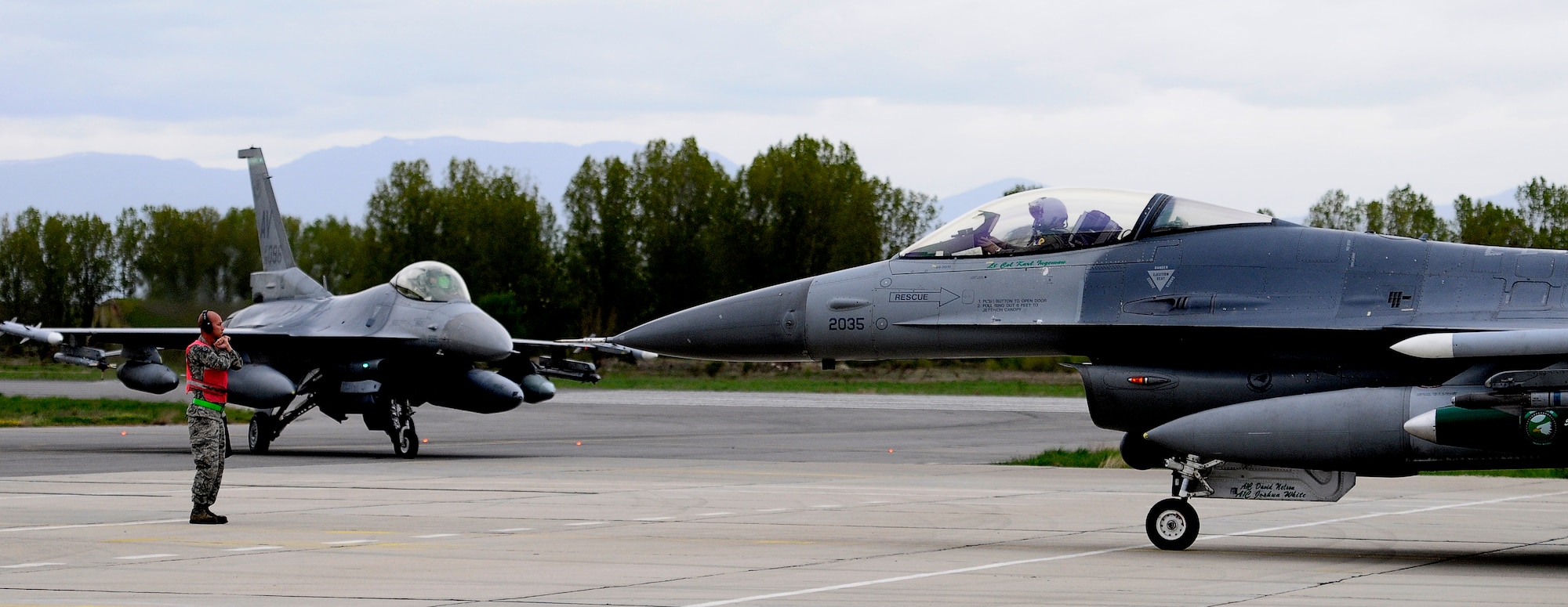 GRAF IGNATIEVO AIR FORCE BASE, Bulgaria -- Staff Sgt. Juan Rodriguez Lopez, 31st Aircraft Maintenance Squadron, marshals in two 555th Fighter Squadron F-16 pilots after landing here April 17, 2012. Graf Ignatievo is now host to more than two dozen F-16 Fighting Falcons and more than 500 U.S. Air Force personnel in support of Thracian Star 2012, a month-long joint training exercise focused on building partnerships and increasing interoperability with the Bulgarian pilots, maintainers, joint terminal air controllers, firefighters and security forces Airmen. (U.S. Air Force photo/Senior Airman Katherine Windish)