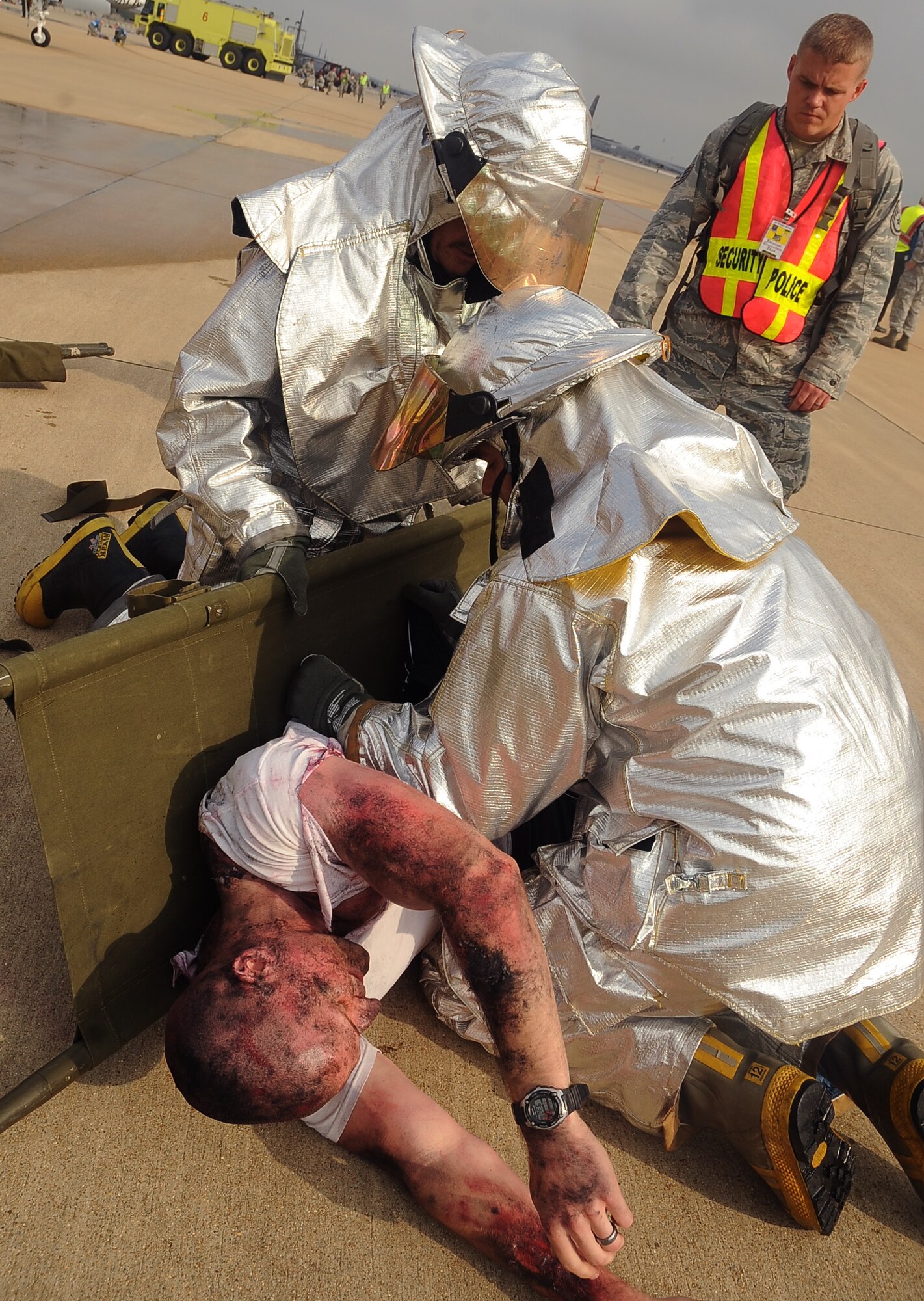 Barksdale firefighters place a simulated victim on a litter during a Major Accident Response Exercise on Barksdale Air Force Base, La., April 13. More than 50 Barksdale Airmen were moulaged for the exercise, assisting exercise evaluation team members in evaluating how medical, security forces and several base and community emergency services responded to the incident. (U.S. Air Force photo/Staff Sgt. Amber Ashcraft) (RELEASED)