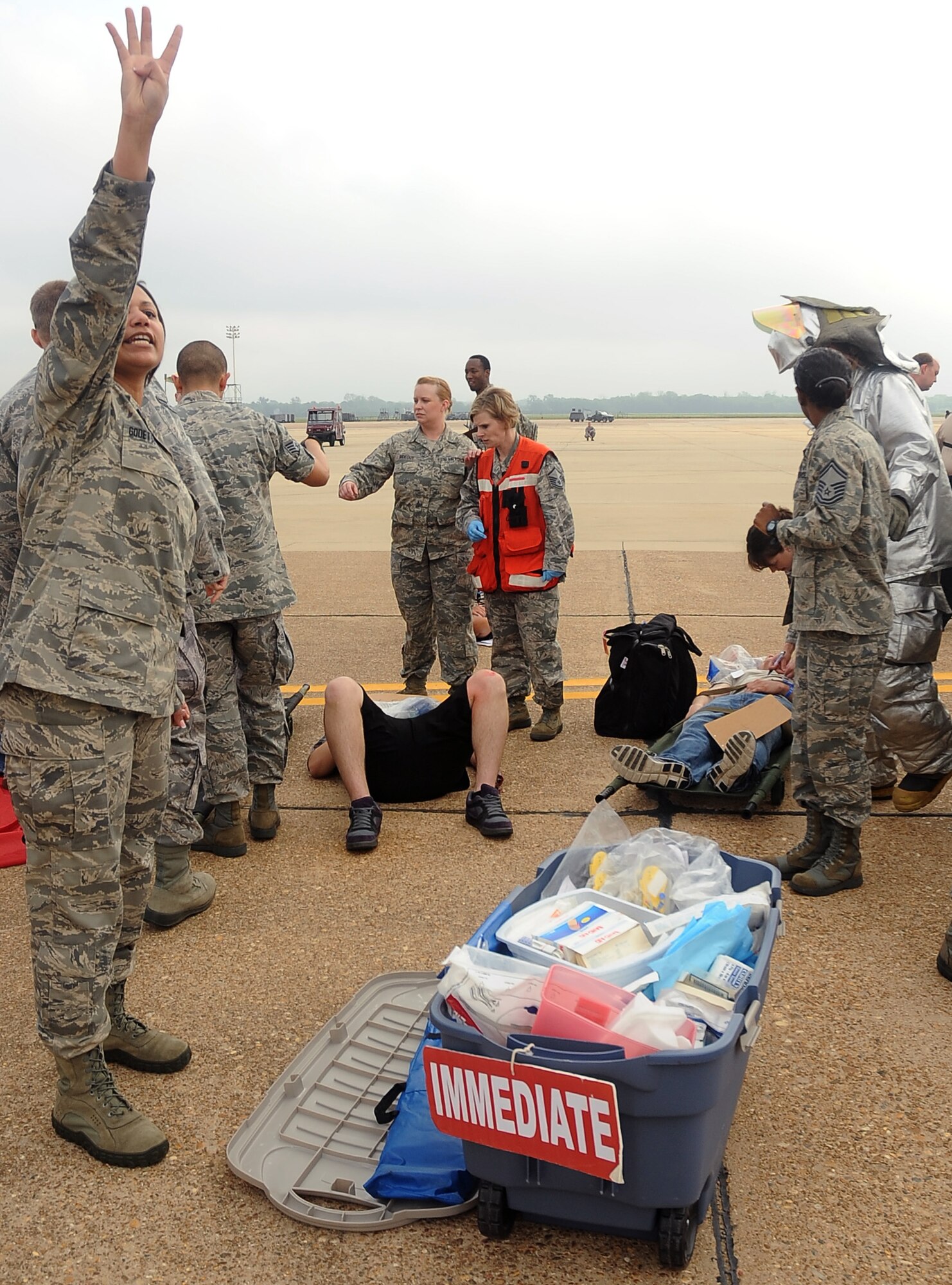 An Airman from the 2nd Medical Group calls for litter carriers to assist a simulated victim during a Major Accident Response Exercise on Barksdale Air Force Base, La., April 13.  More than 50 Barksdale Airmen were moulaged for the exercise, assisting exercise evaluation team members in evaluating how medical, security forces and several base and community emergency services responded to the incident. (U.S. Air Force photo/Staff Sgt. Amber Ashcraft) (RELEASED)