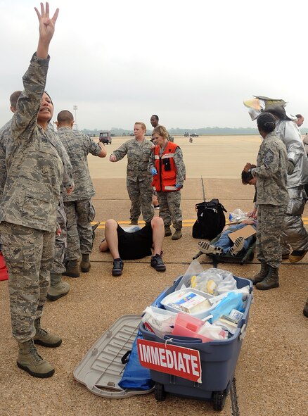 An Airman from the 2nd Medical Group calls for litter carriers to assist a simulated victim during a Major Accident Response Exercise on Barksdale Air Force Base, La., April 13.  More than 50 Barksdale Airmen were moulaged for the exercise, assisting exercise evaluation team members in evaluating how medical, security forces and several base and community emergency services responded to the incident. (U.S. Air Force photo/Staff Sgt. Amber Ashcraft) (RELEASED)