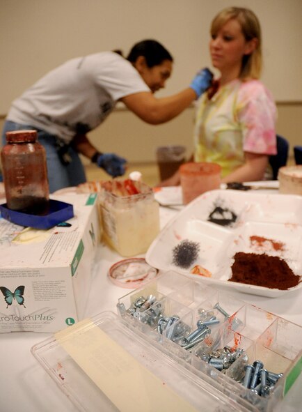 A 2nd Medical Group Airman places make-up on a simulated victim prior to the start of a Major Accident Response Exercise on Barksdale Air Force Base, La., April 13. More than 50 Barksdale Airmen were moulaged for the exercise, assisting exercise evaluation team members in evaluating how medical, security forces and several base and community emergency services responded to the incident. (U.S. Air Force photo/Staff Sgt. Amber Ashcraft) (RELEASED)