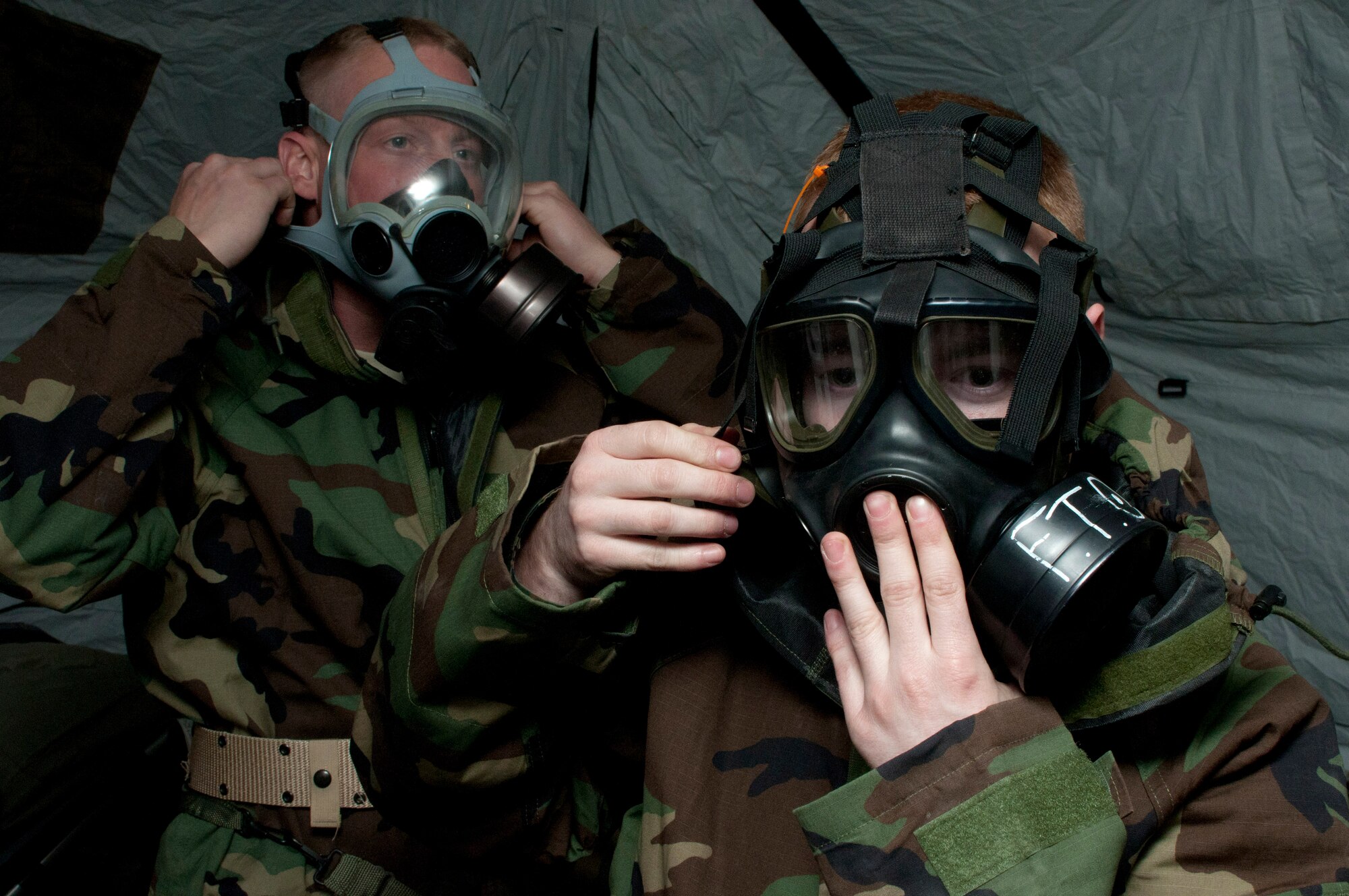 Senior Airman Craig M. Vonholtum from the 208th Weather Flight of the Minnesota Air National Guard and Lance Corporal Brandon Bergman from Marine Wing Support Squadron 471 US Naval- Marine Corps Reserve Readiness Center secure their gas masks during a simulated chemical attack Apr. 14, 2012. Sixteen members of the 208th along with three U.S. Marines from the Marine Wing Support Squadron 471 US Naval- Marine Corps Reserve Readiness Center Minneapolis are taking part in a field training exercise during week of Apr. 8, 2012. USAF photo by Tech. Sgt. Erik Gudmundson