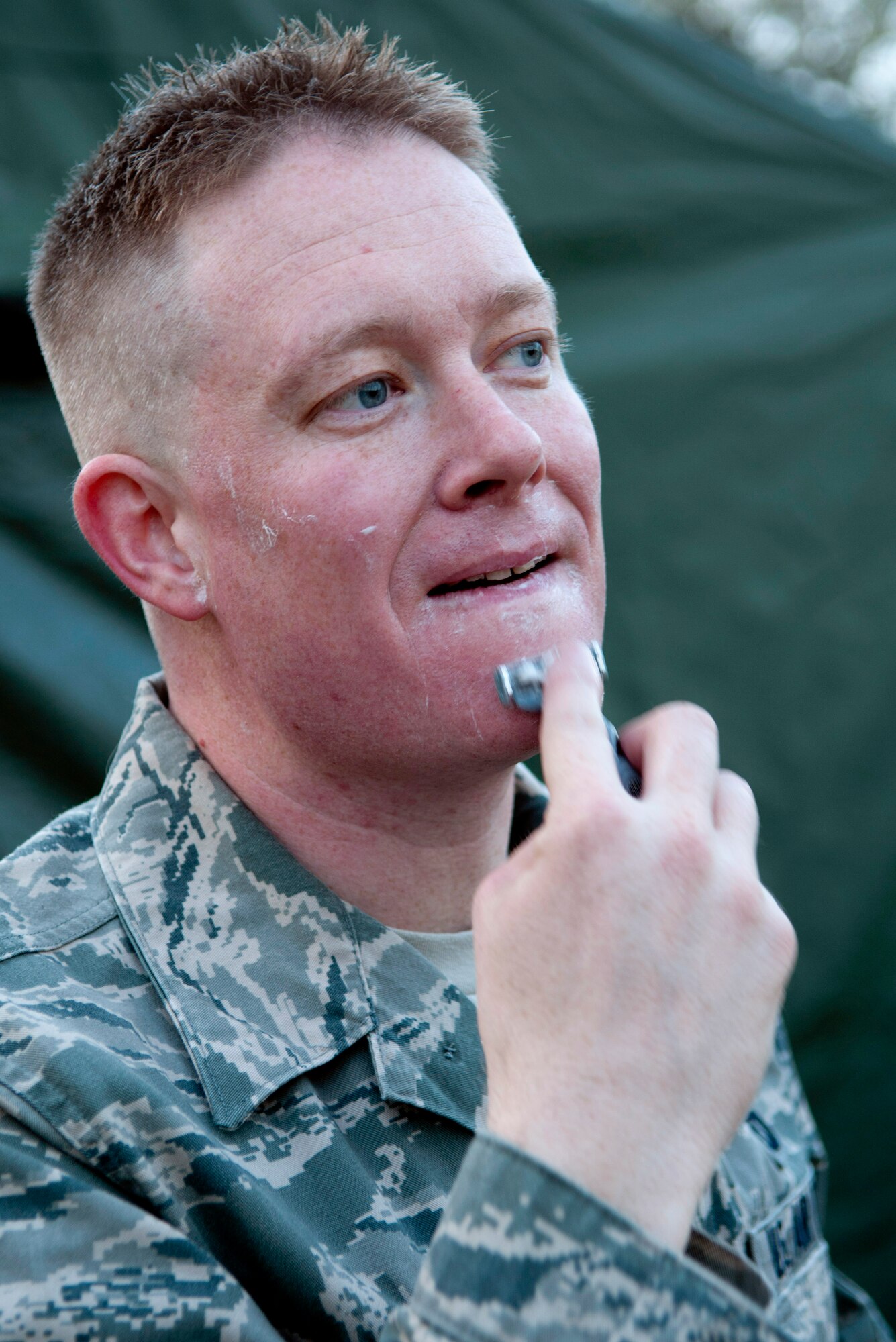 Senior Airman Robert T. Zweber from the 208th Weather Flight of the Minnesota Air National Guard shaves outside in the frigid early morning light at William O’Brien State Park on the St. Croix River, MN Apr. 14, 2012. Sixteen members of the 208th along with three U.S. Marines from the Marine Wing Support Squadron 471 US Naval- Marine Corps Reserve Readiness Center Minneapolis are taking part in a field training exercise during week of Apr. 8, 2012. USAF photo by Tech. Sgt. Erik Gudmundson
