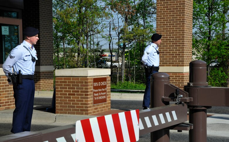 Airmen 1st Class Robert Dorsey,left, and Jeffrey Weaver, right, Andrews Elite Gate Guardsmen, checks IDs and greets Andrews’ morning commuters on the morning of April 16. (U.S. Air Force Photo/Airman 1st Class Lindsey A. Porter)  