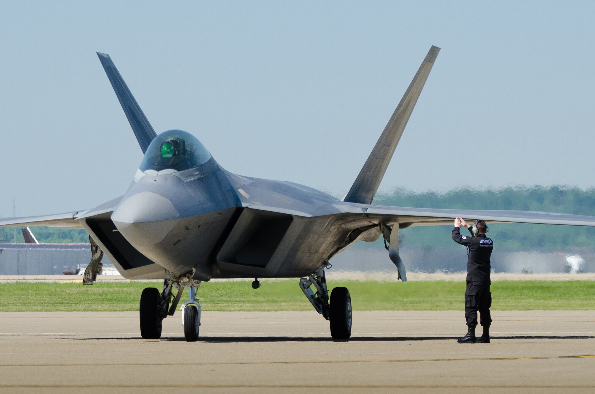 A crew chief for the U.S. Air Force F-22 Raptor Demo Team provides direction for a pilot as the aircraft arrives at the Kentucky Air National Guard Base in Louisville, Ky., on April 18, 2012, in preparation for this weekend's 22nd annual Thunder Over Louisville air show. The Raptor is the U.S. military's premier fighter aircraft, with capabilities that are unmatched by any other plane. (U.S. Air Force Photo by Maj. Dale Greer)
