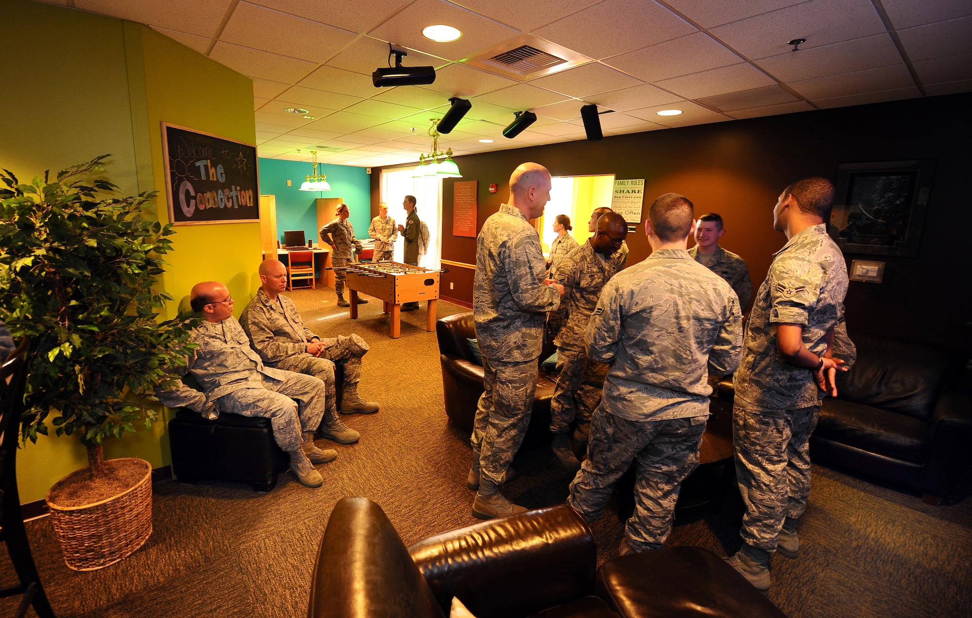 Offutt Airmen gather in The Connection, a dormitory morale room, which was recently re-located to the third floor of the Tuskegee Hall dormitories.  Dorm residents were given a creative say in what they wanted in the center right down to the color of the walls. The center provides Airmen with a computer workstation, full kitchen, gaming room, high definition television and a coffee station.  (U.S. Air Force photo by Josh Plueger/Released).