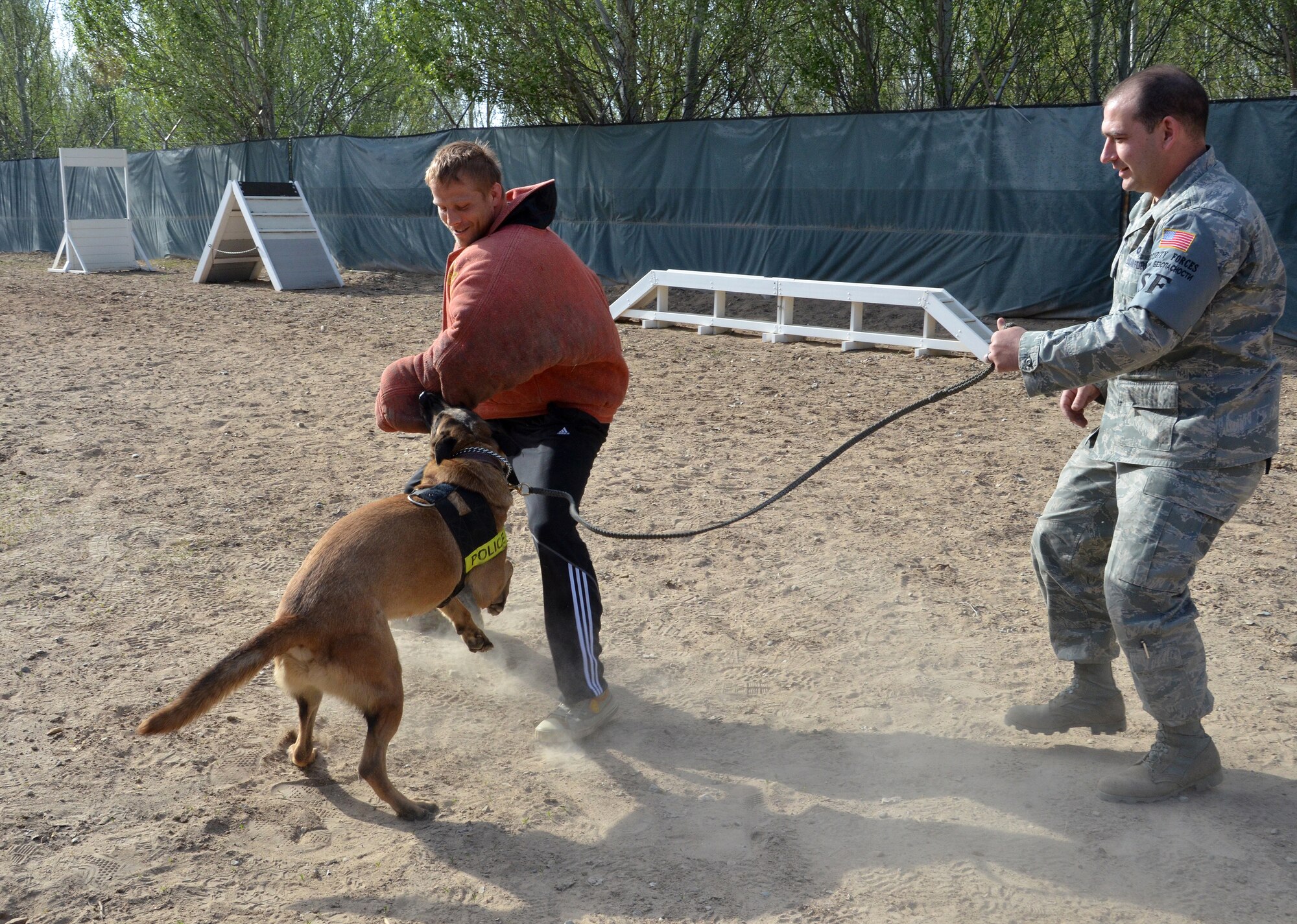 During an Armed Forces Entertainment tour to the Transit Center at Manas, Kyrygzstan, Ultimate Fighting Championship fighter Nick Ring participates in a military working dog demonstration at the 376th Expeditionary Security Forces Squadron kennel April 14, 2012. Staff Sgt. Joshua Hayes, 376 ESFS dog handler and military working dog, Brit, performed two attack sequences with two different UFC fighters. Hayes is deployed here from Travis Air Force Base, Calif., and his hometown is Sacramento, Calif. (U.S. Air Force photo/Courtesy Photo)