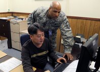 Senior Master Sgt. Jonathon Curl, Pacific Air Force Inspector General team member, observes Yun Ku Ok, 8th Logistics Readiness Squadron traffic management specials, input shipping orders on Kunsan Air Base, Republic of Korea, April 19, 2012. As part of the new Consolidated Unit Inspection, Air Force leaders have worked to merge inspections, assessments and staff assistance visits to give commanders more time to focus on mission tasks. (U.S. Air Force photo/Senior Airman Jessica Hines)