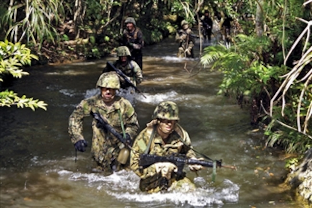 U.S. Marines and sailors run through a stream at the endurance course at the Jungle Warfare Training Center at Camp Gonsalves, Okinawa, Japan, on April 8, 2012.  The Marines and sailors are assigned to Combat Logistics Regiment 37, 3rd Marine Logistics Group, 3rd Marine Expeditionary Force and Naval Mobile Construction Battalion 40, 31st Seabee Readiness Group.  The course includes numerous water obstacles.  