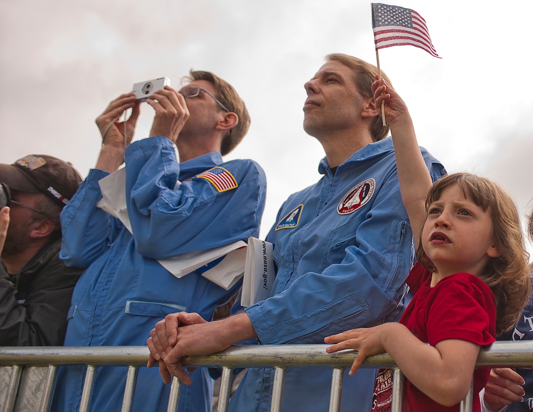 Hilarie Stockton waves her American flag during the United States Marine Drum & Bugle Corps performance as part of the Discovery Transfer Ceremony at the Smithsonian National Air and Space Museum April 19.