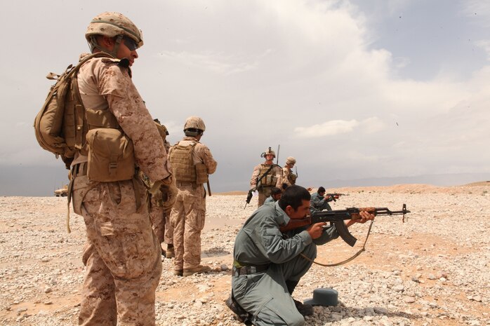 Corporal Edgar Rodriguez, a squad leader serving with 1st Battalion, 8th Marine Regiment, Police Advisory Team 1, instructs an Afghan Uniformed Police officer firing an AK-47 assault rifle here, April 19, 2012. Rodriguez, 23, a native of New York City, helps train Afghan security forces develop to be self-sufficient. (U.S. Marine Corps photo by Lance Cpl. Tyler Reiriz)