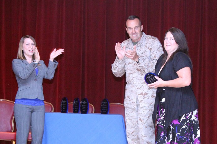 Candi Heinberger(left), volunteer program coordinator with Marine Corps Community Services Marine and Family Programs Division, and Brig. Gen. Vincent Coglianese (center), commanding general of Marine Corps Installations West, congratulate Katherine Cordle (right), volunteer, during a recognition ceremony at the Pacific Views Event Center at Camp Pendleton, Calif., April 19.  Cordle received an award for Civilian Volunteer of the Year. She served more than 1,040 hours in 2011 and is actively involved in supporting Marines, sailors and families of 1st Battalion, 11th Marine Regiment,  1st Marine Division. Cordle also volunteers with Wounded Warrior Battalion West.