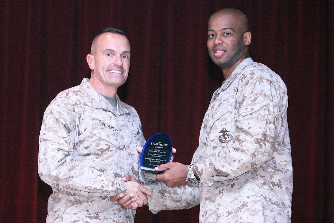 Maj. Carlos Jackson (right), executive officer of 3rd Assault Amphibian Battalion, accepts an award from Brig. Gen. Vincent Coglianese (left), commanding general of Marine Corps Installations West, for Small Unit Volunteer of the Year on behalf of 3rd Assault Amphibian Bn., during a volunteer recognition ceremony at the Pacific Views Event Center at Camp Pendleton, Calif., April 19. The group of approximately 58 Marines contributed more than 812 hours of service in 2011. Volunteers helped raise thousands of dollars for cancer research during the Westminster 24-hour "Relay for Life" and provided service for Santa Margarita Elementary School.