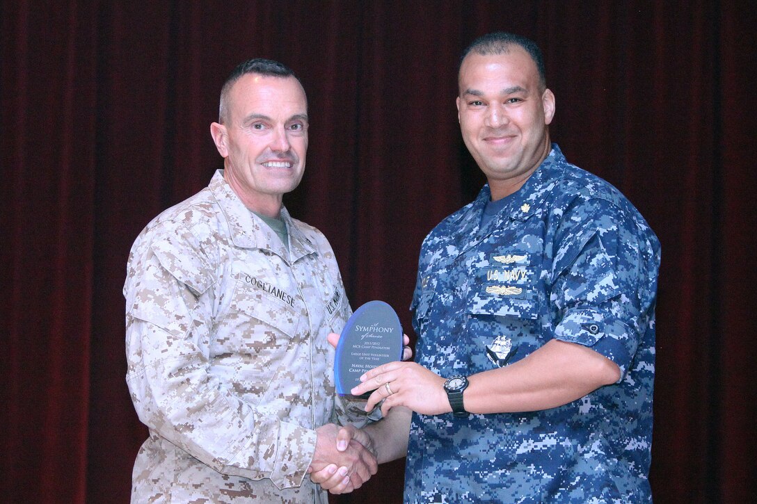 Navy Capt. Theron C. Toole (right), chief of medical staff, accepts an award from Brig. Gen. Vincent Coglianese (left), commanding general of Marine Corps Installations West, for Large Unit Volunteer of the Year on behalf of Naval Hospital, Camp Pendleton during a volunteer recognition ceremony at the Pacific Views Event Center at Camp Pendleton, Calif., April 19. The unit served more than 18,000 hours in 2011 coordinating food and toy drives, festivals, coaching Special Olympics athletes, the School to Center Program, assisting the Wounded Warriors Program, and providing services both on and off base.