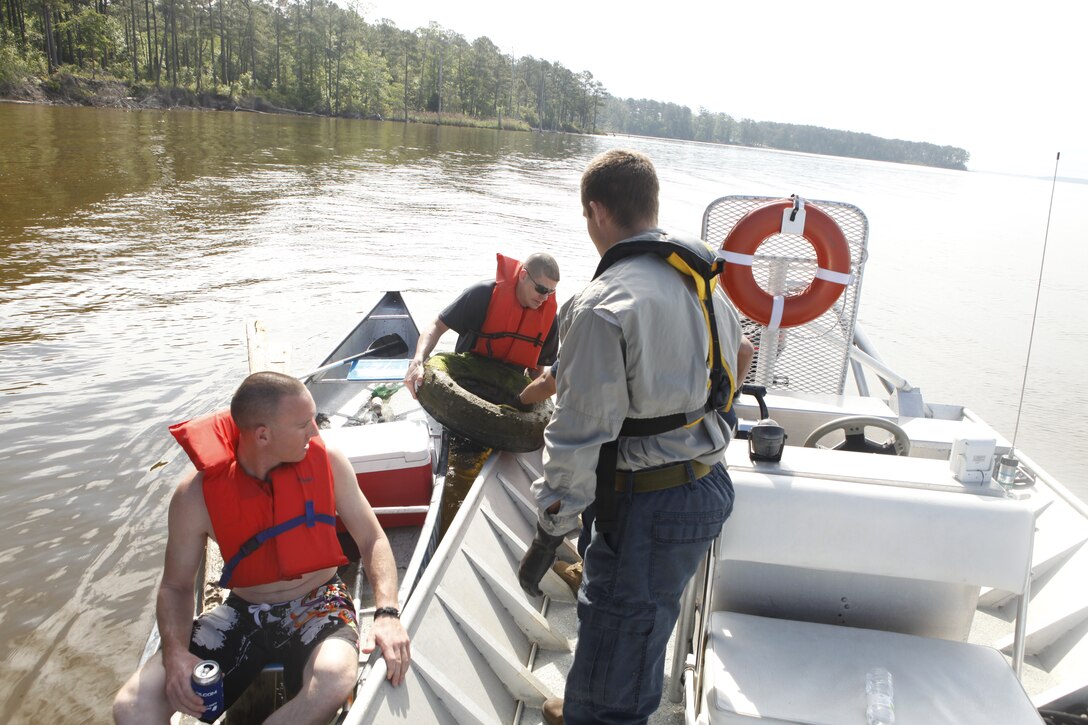 Volunteers load trash from their canoe onto a larger boat during the Splash for Trash event held April 20 along the shorelines of Marine Corps Base Camp Lejeune in celebration of Earth Day.